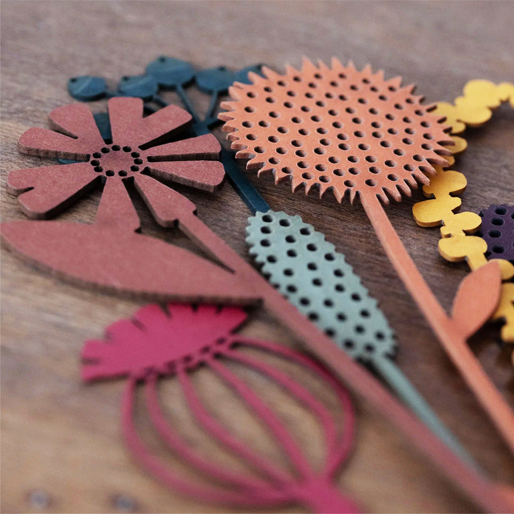 Close up of joyful posy of spring flowers from artist Hannah Nunn's collection of all-year-round bouquets of meadow flowers and grasses and joyful sunflowers to hang in your window. Laser cut from colourful card in her Hebden Bridge studio.
