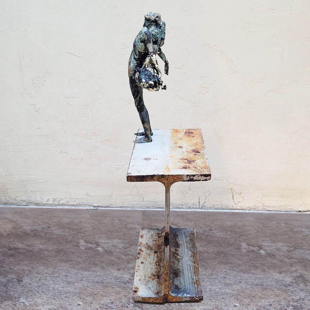 A side view of Johnny Vegas Sculpture - Motion captured 3D printed figure mounted on a salvaged RSJ steel girder featuring gold and silver leaf