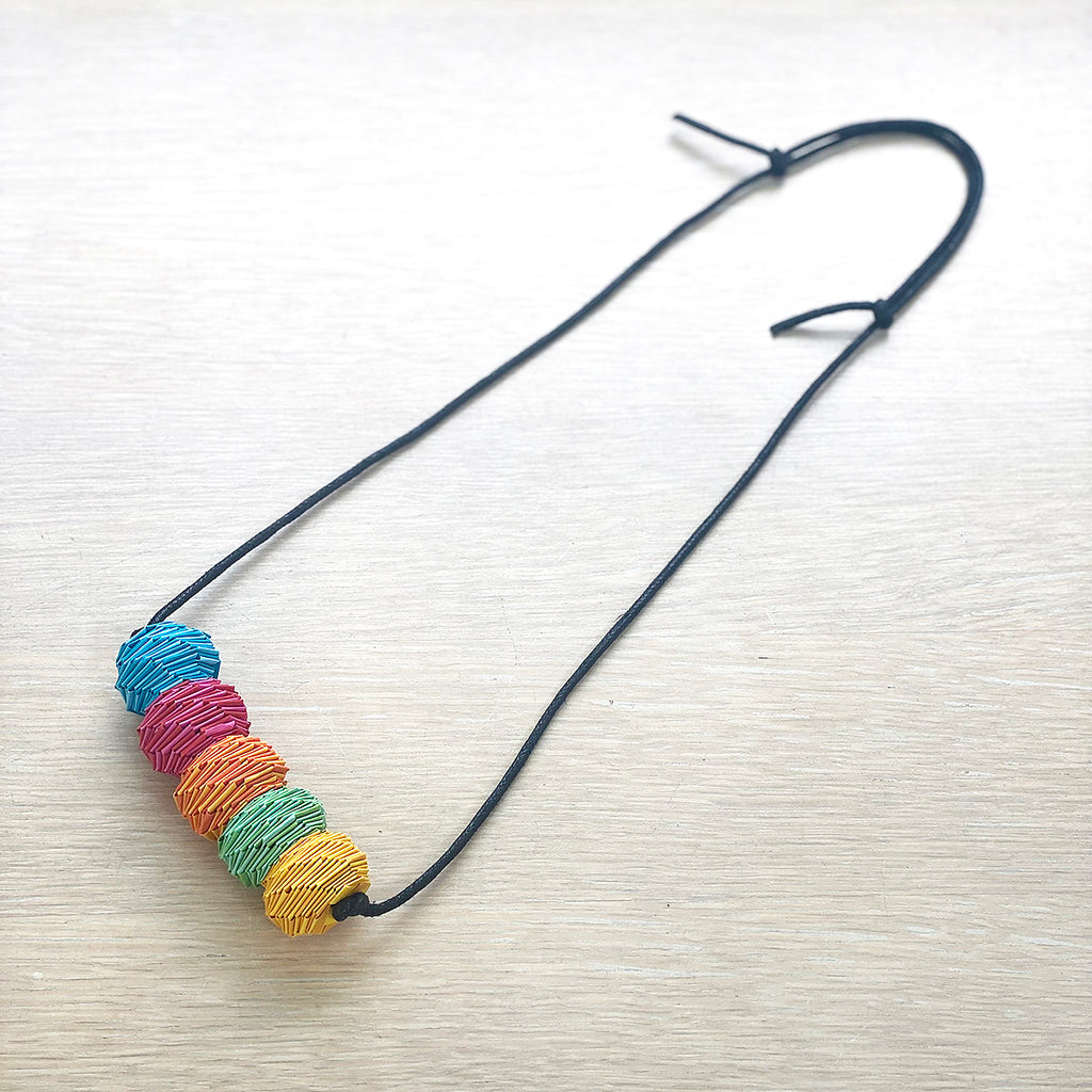 A multicolored paper beaded necklace with an adjustable leather strap by Irish maker Rike Lenzing shown at the bluecoat display centre