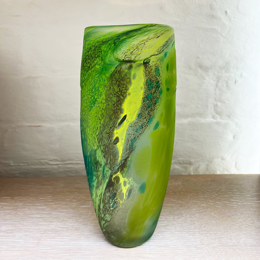 Green glass vase from Will Shakspeare's 'Random Trails' range, inspired by walking in the Elan Valley in Wales.  This vase is predominently green with varying shades, plus blue and yellow highlights shown here
