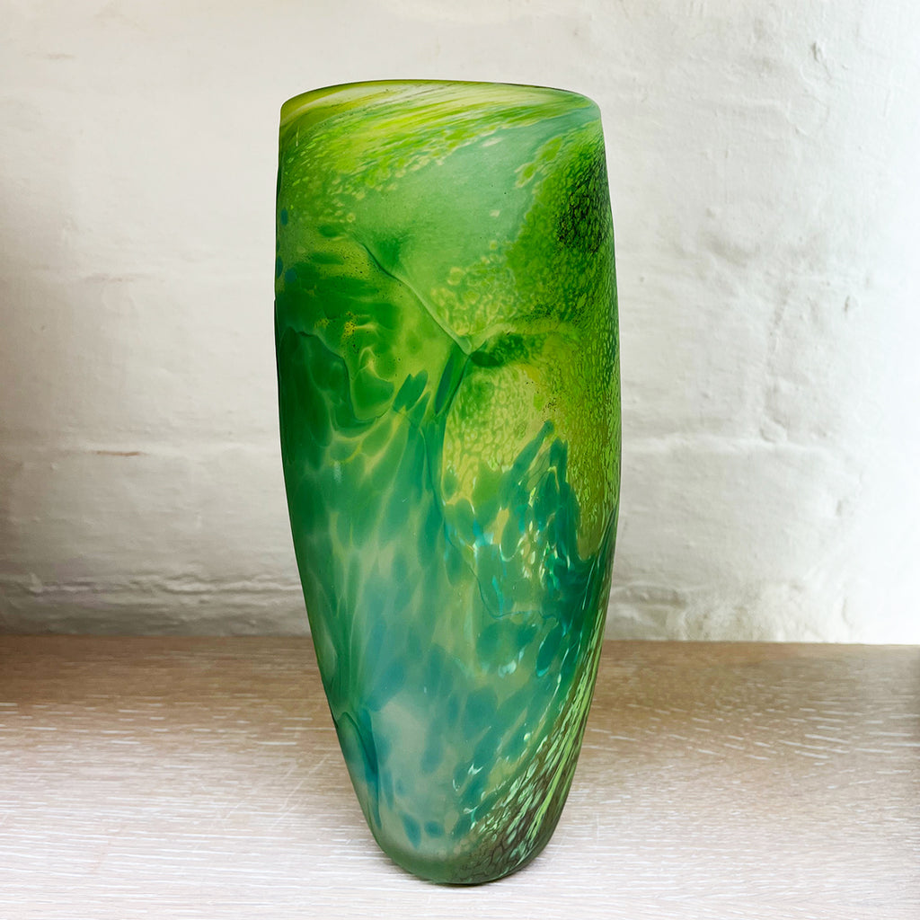 Green glass vase from Will Shakspeare's 'Random Trails' range, inspired by walking in the Elan Valley in Wales.  This vase is predominently green with varying shades, plus blue and yellow highlights one angle shown