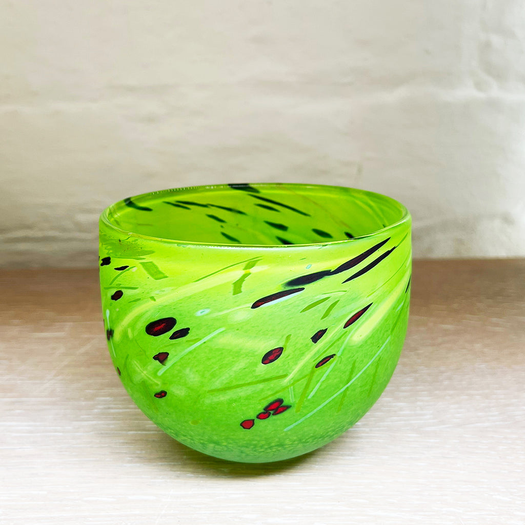 A small bowl by contemporary glass artist Will Shakspeare. The piece is inspired by the landscape of the Somerset Levels and is predominently green in colour with accents in red, black and white
