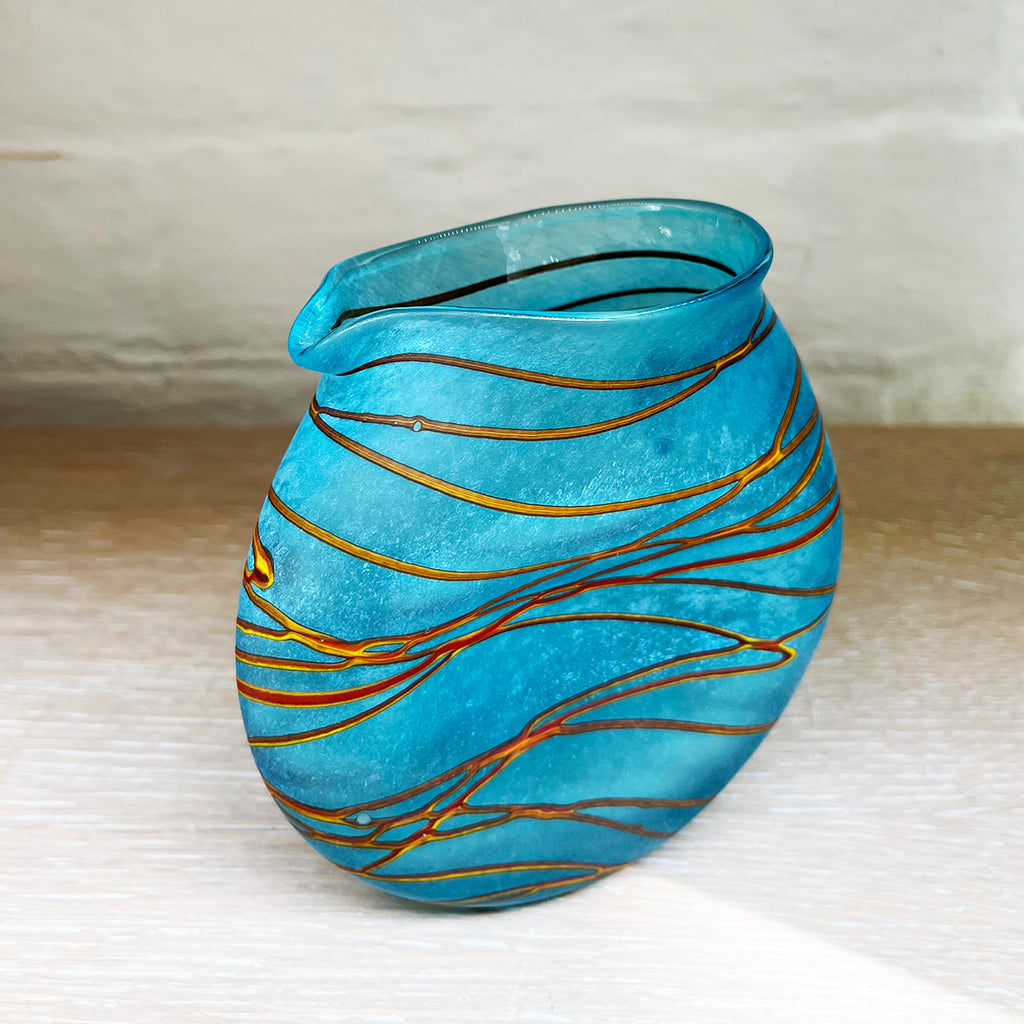 side view of small aqua clutch jug from Will Shakspeare's 'Random Trails' range, inspired by walking in the Elan Valley in Wales.   Will has been making his own inimitable glassware for nearly 30 years and is one of the country's most collected makers