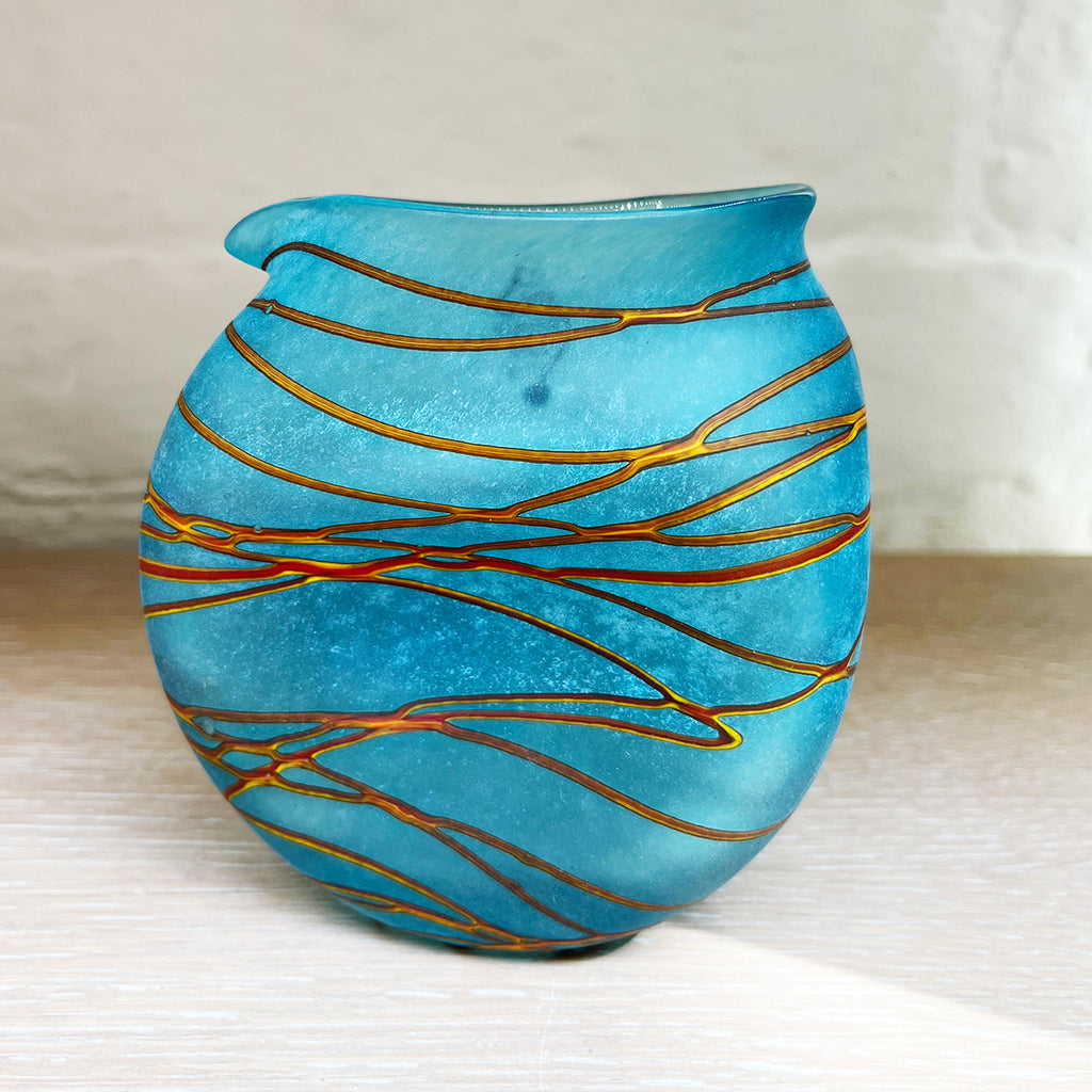 A small clutch jug from Will Shakspeare's 'Random Trails' range, inspired by walking in the Elan Valley in Wales.  This contemporary glass jug is predominently aqua with threads of gold colour. Will has been making his own inimitable glassware for nearly 30 years and is one of the country's most collected makers