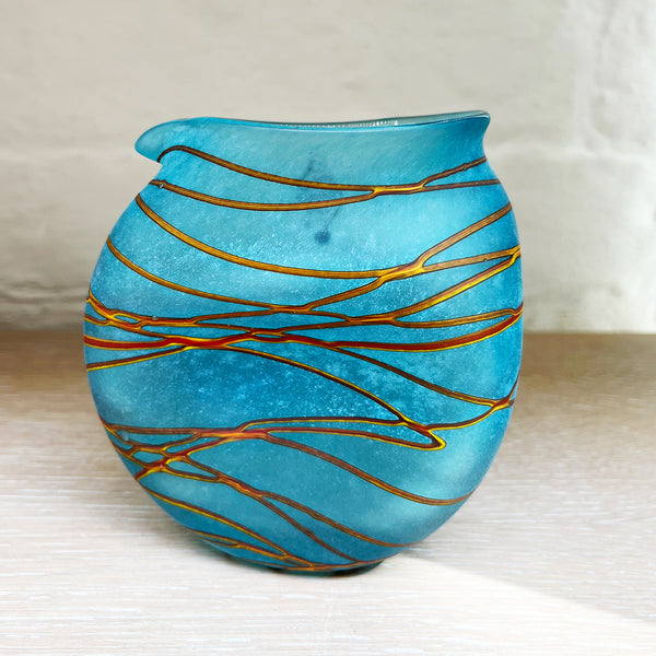 A small clutch jug from Will Shakspeare's 'Random Trails' range, inspired by walking in the Elan Valley in Wales.  This contemporary glass jug is predominently aqua with threads of gold colour. Will has been making his own inimitable glassware for nearly 30 years and is one of the country's most collected makers