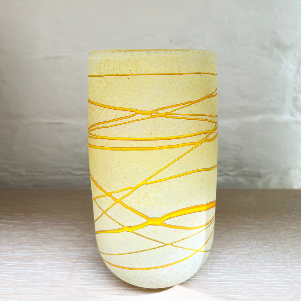 A vase from Will Shakspeare's 'Random Trails' range, inspired by walking in the Elan Valley in Wales.  This vase is predominently a vanilla colour with threads of gold colour. Will has been making his own inimitable glassware for nearly 30 years and is one of the country's most collected makers