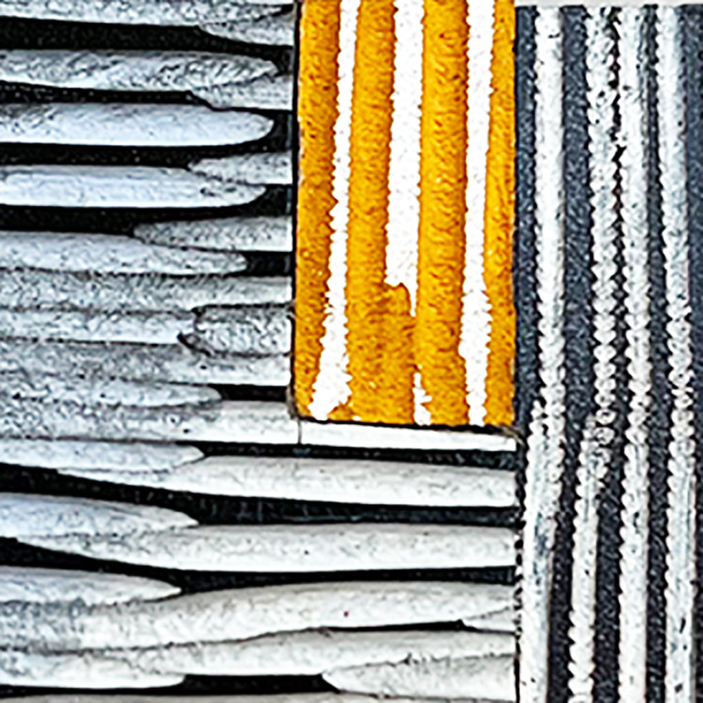 close up of the detail of orange grey and black leather brooch