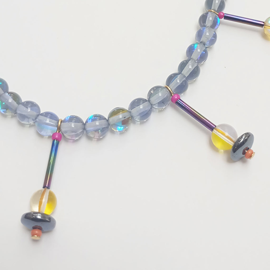 close up of part of unique and stunning dyed quartz bead necklace with bugle style beads, and single quartz beads with a sterling silver clasp by alan phillips