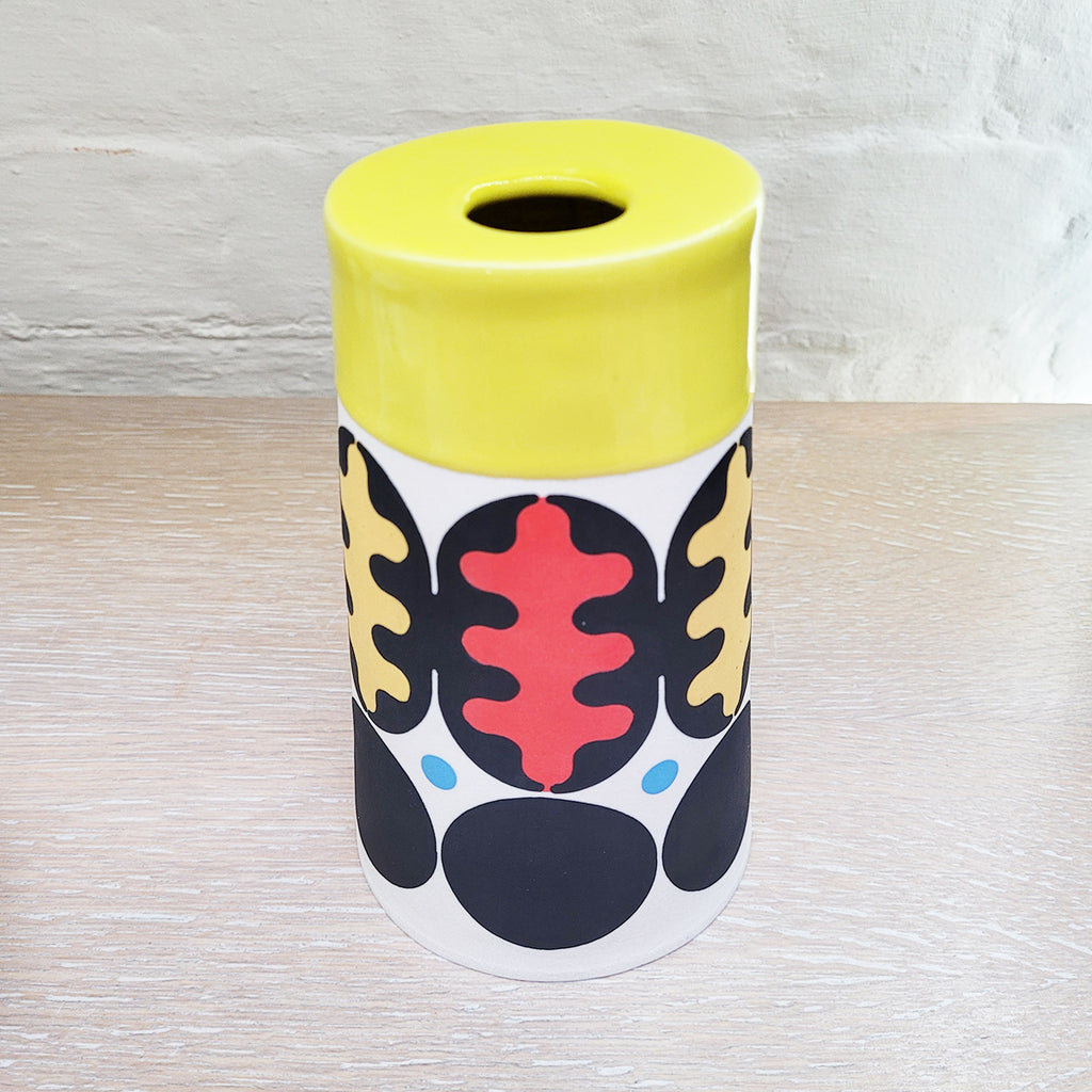 Top view of Large Flat Top Cone Vase decorated using stencils and slip colours. With a distinctively mid-centurary modern feel about it - this piece is predominently white background and navy with red, blue and peach accents and a yellow top section. It is by contemporary ceramics duo MapMap
