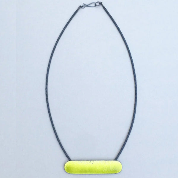 bright acid yellow necklace with a long horizontal textured shape partly enamelled strung on cable with tiny gunmetal colour glass seed beads by Annabet Wyndham