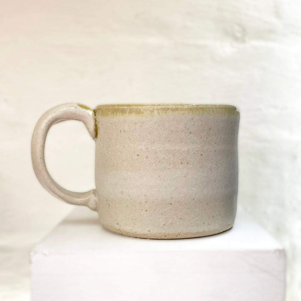 back of beautiful hand thrown mug adorned with a bird sitting upon a cherry blossom branch by Julia Smith.
