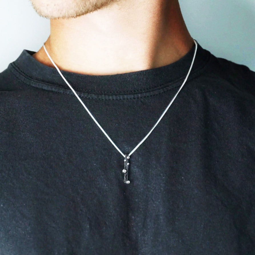 Person in Black TShirt wearing Cascade 1 Pendant in Silver with moissanite by Contemporary Jeweller Sam Holmes
