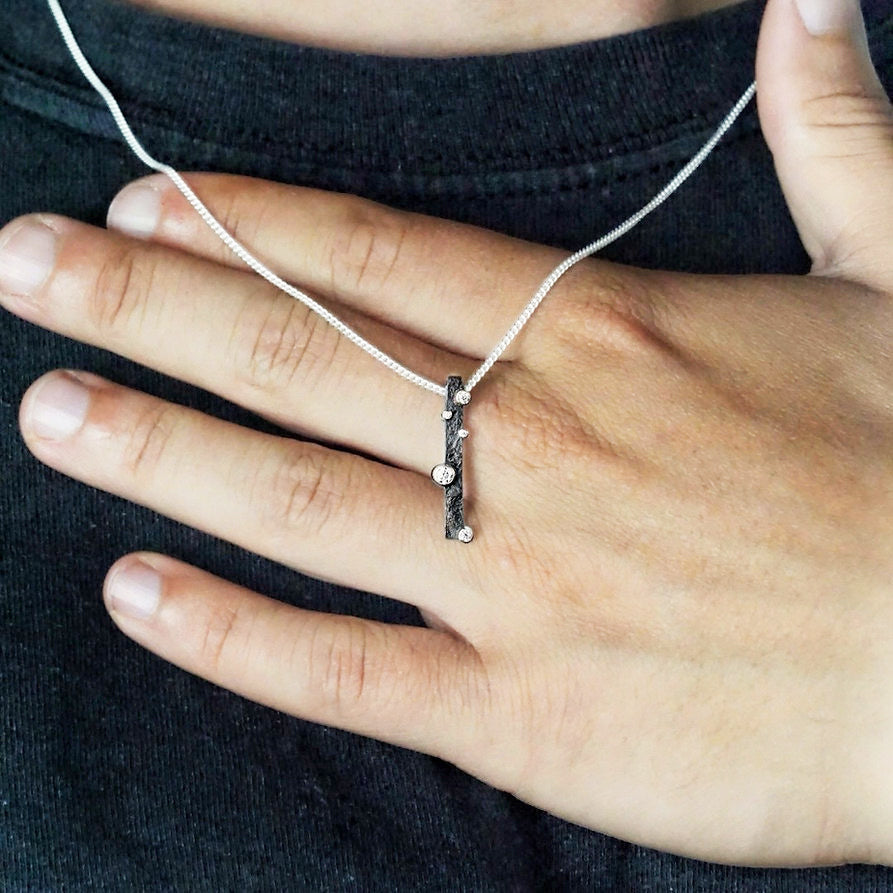 Detail of Cascade 1 Pendant in Silver with moissanite by Contemporary Jeweller Sam Holmes whilst being worn