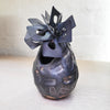 contemporary ceramic vessel made from oxidised copper & clay. This piece features organic square shaped adornments and a dark glaze.