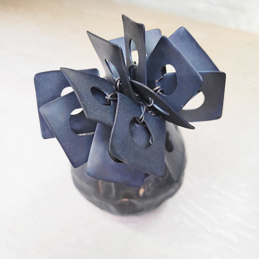 top view of contemporary ceramic vessel made from oxidised copper & clay. This piece features organic square shaped adornments and a dark glaze.