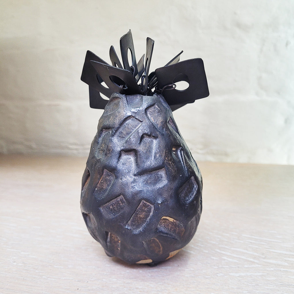 back view of contemporary ceramic vessel made from oxidised copper & clay. This piece features organic square shaped adornments and a dark glaze.