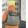 Olive grey backpack with colorful strap shown worn and made from faux leather by Studio Ditto