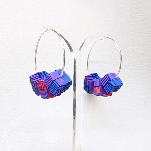 beautiful hoop earrings adorned with three small, decorated paper cubes by Rike Lenzing in purple, blue and cerise photographed at the Bluecoat Dispaly Centre