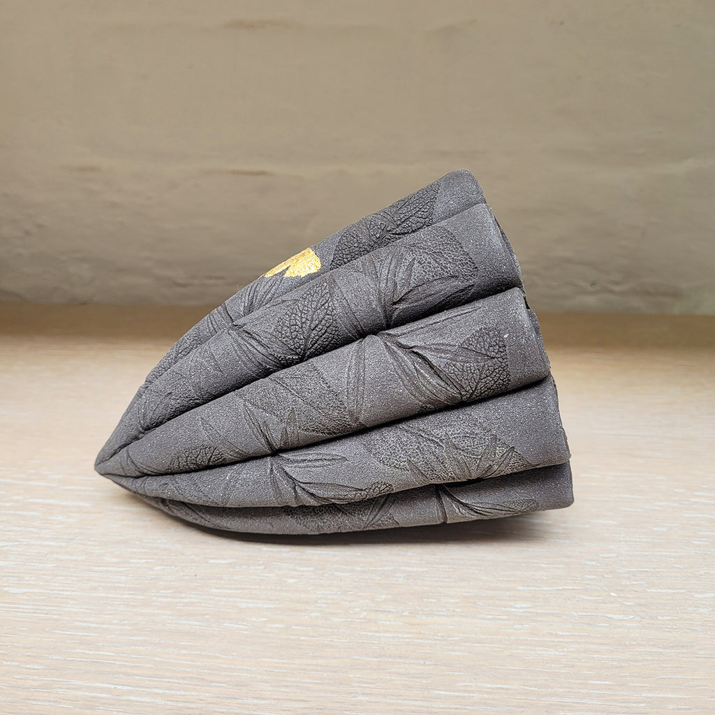 right side view of contemporary ceramic dark leaf pod by Ellul Ceramics featuring 24ct gold leaf