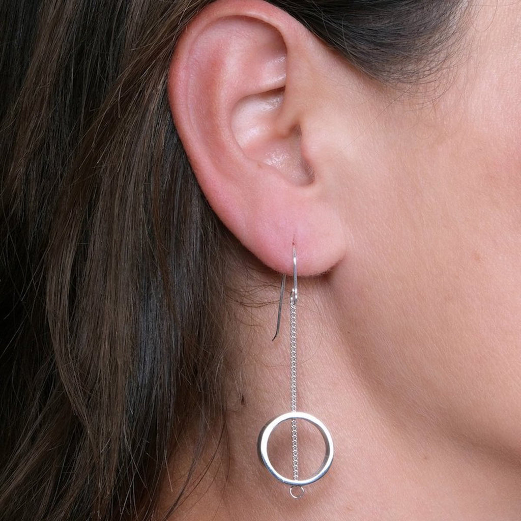 Close-up of an ear wearing chain drop sterling silver earrings by Maureen Lynch.