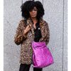 Studio Ditto Fuchsia Pink Faux Leather bag worn as a tote by model in a leopard print coat