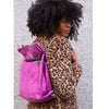 Studio Ditto Fuchsia Pink Faux Leather bag worn as backpack by model in a leopard print coat