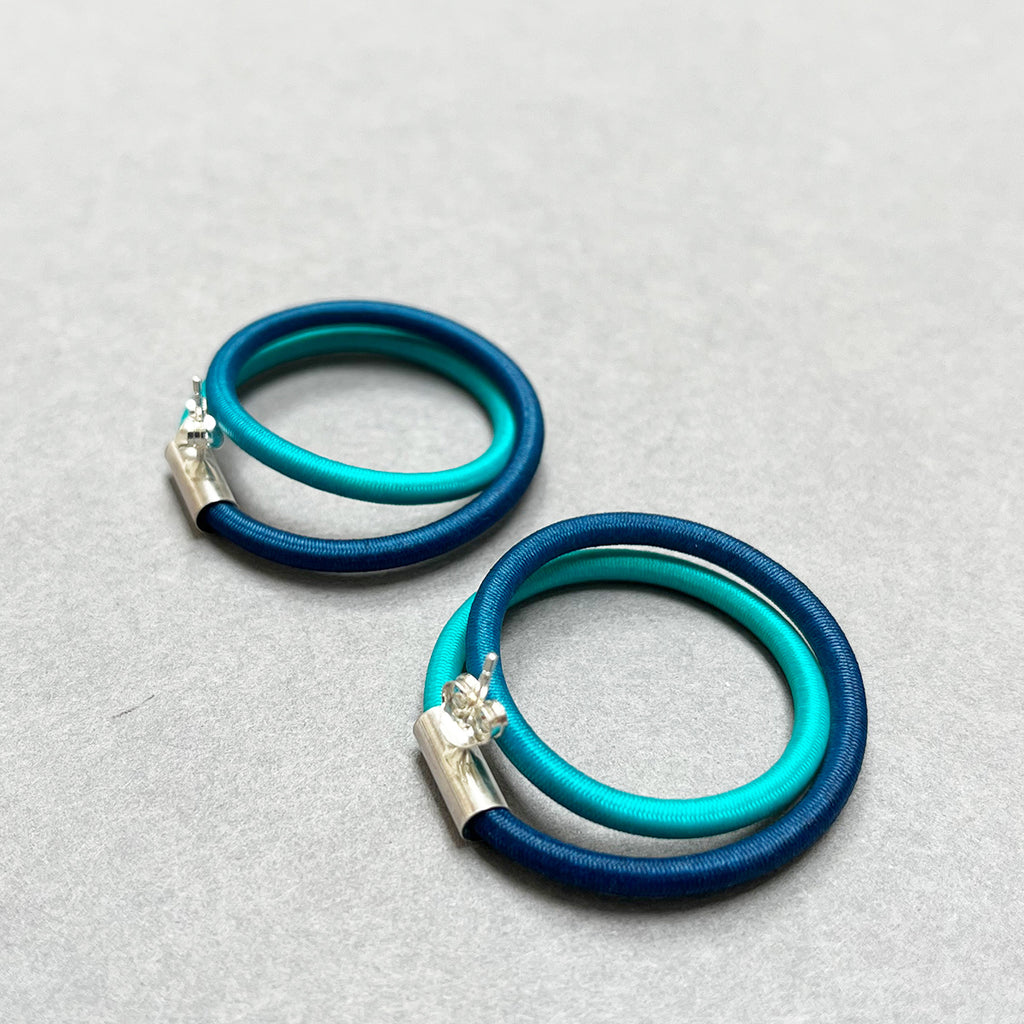 the back of contemporary blue green double loop earstuds are the perfect way to add a pop of colour to any outfit. In silver and hand dyed elastic by Gilly Langton