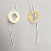 inspired by birds nests and natural structures, these earrings on long silver wires, feature individual textured silver and gold circles assembled into a wrapped nest