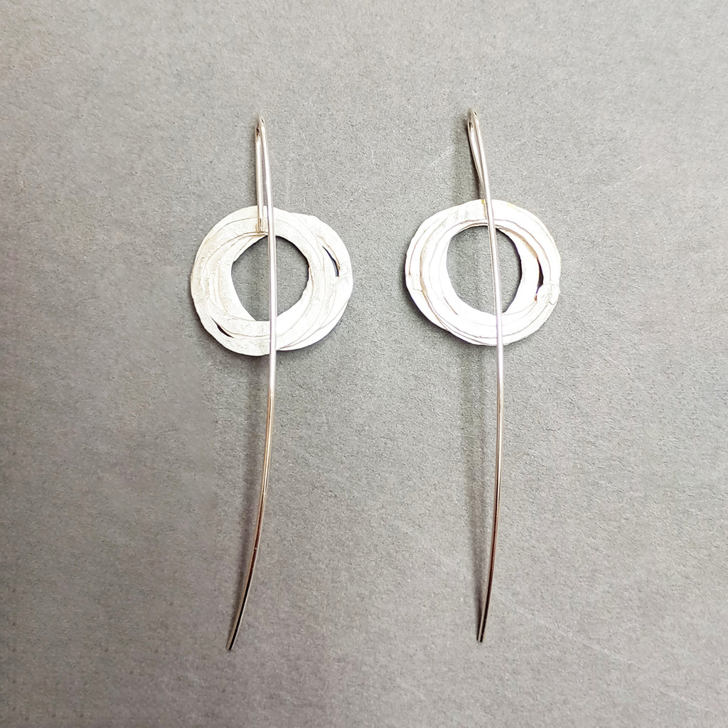 Reverse of earrings inspired by birds nests and natural structures, these earrings on long silver wires, feature individual textured silver and gold circles assembled into a wrapped nest