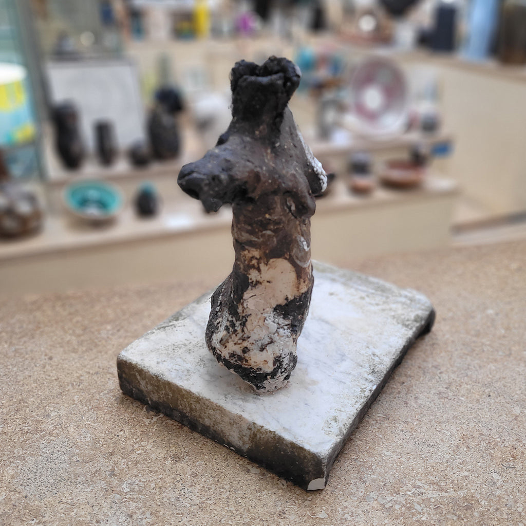 Stagnation of Soul, a Johnny Vegas Female torso sculpted from black clay and mounted on a salvaged stone base - side view in situ at Bluecoat Display Centre, Liverpool