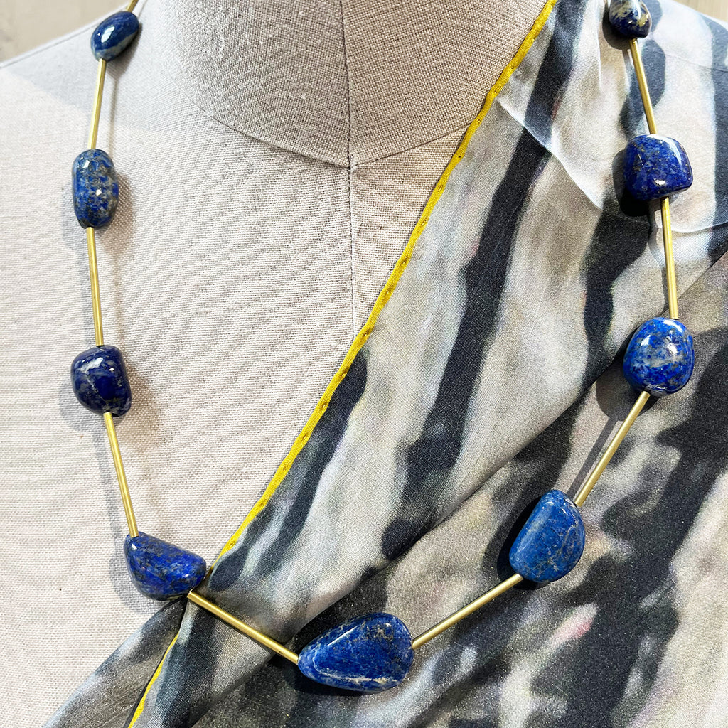 Lapis lazuli and brass necklace with a handmade brass catch by local maker Kate Moult. Photographed on a manequin over a black and white scarf
