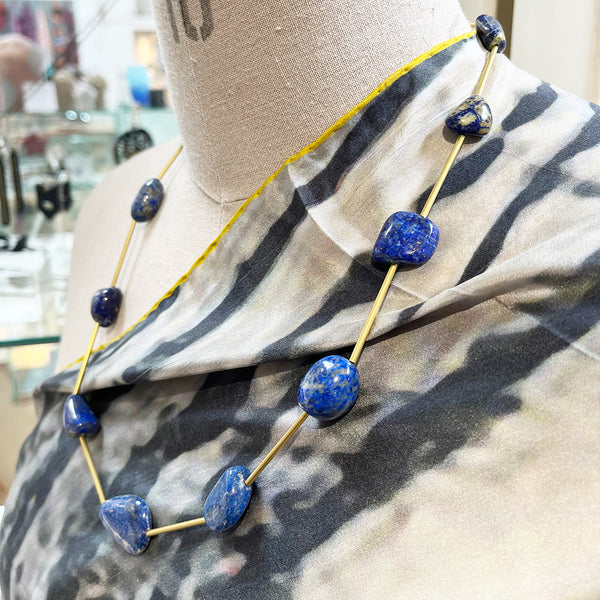 Lapis lazuli and brass necklace with a handmade brass catch by local maker Kate Moult. Photographed on a manequin over a scarf