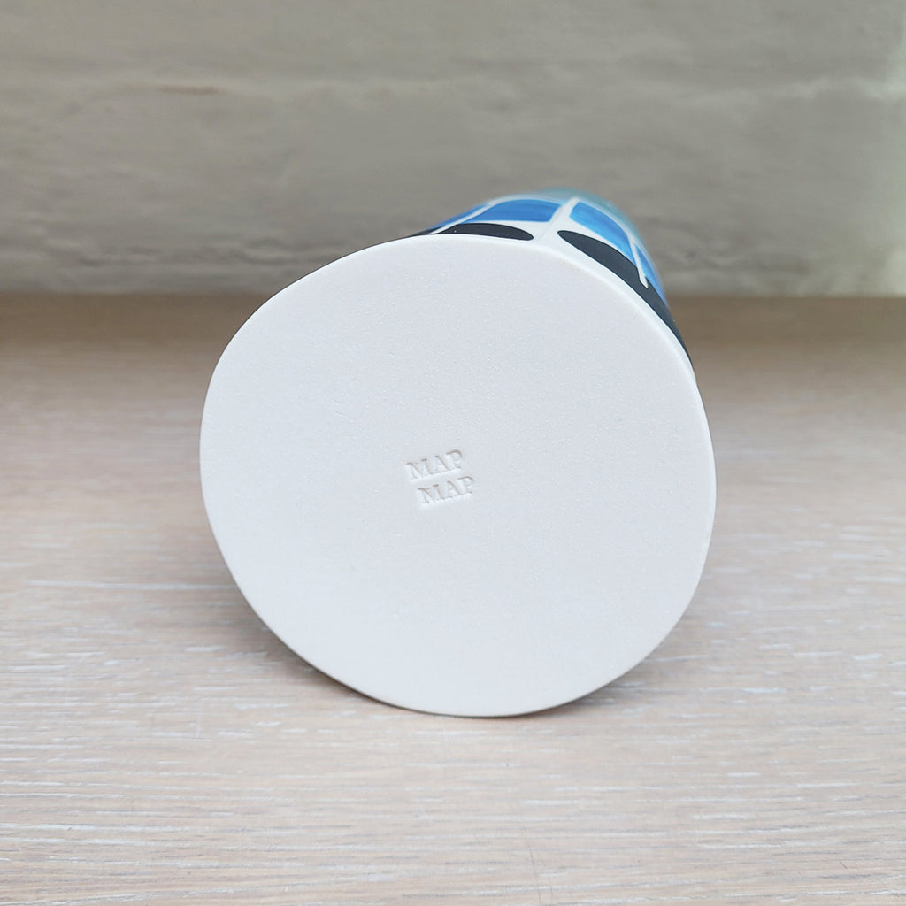 The base of Large contemporary ceramic cone bottle by MAP MAP which shows the makers mark. this piece is predominently white background with shades of blue and black in the pattern