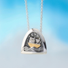 silver kinetic pendant by Alan Ardiff Contemporary Irish Jeweller.  based on the famous poem the owl and the pussycat. The pendant features a silver owl and pussycat going to sea in a gold boat amongst the rocking waves.