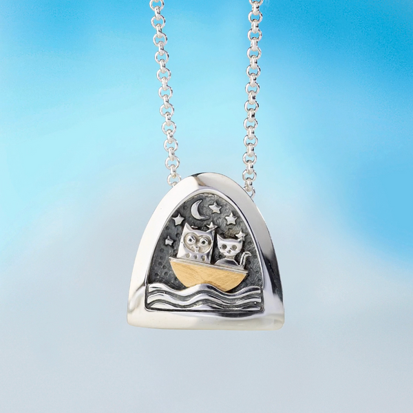 silver kinetic pendant by Alan Ardiff Contemporary Irish Jeweller.  based on the famous poem the owl and the pussycat. The pendant features a silver owl and pussycat going to sea in a gold boat amongst the rocking waves.