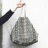 Person holding a Naturally dyed & Hand Block Printed Bag by Louisa Loakes against a light background