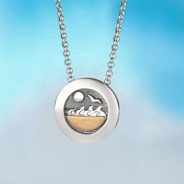 silver kinetic pendant by Contemporary Irish Jewellery Alan Ardiff which features a gold beach landscape that creates rolling waves as you move the chain