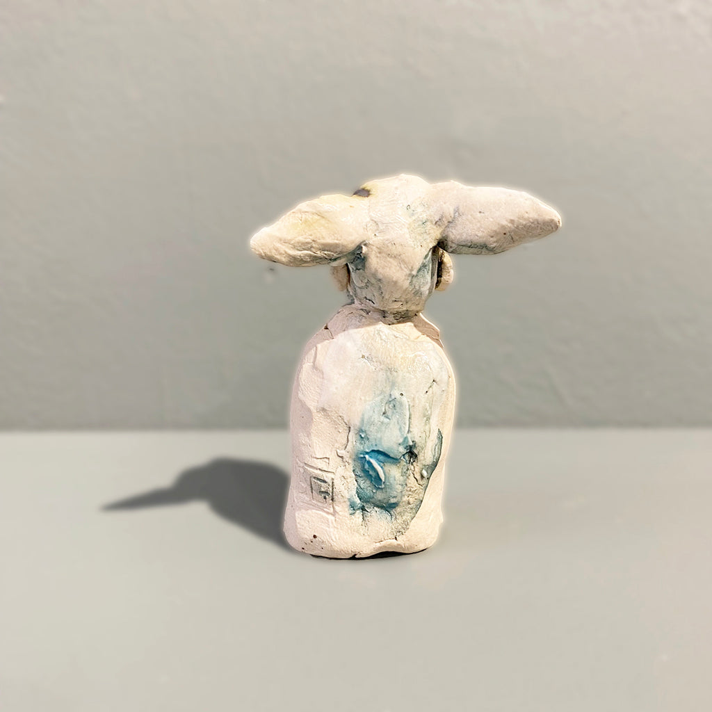Rear View of Miniature figure with large 'listening ears' loosely inspired by creation stories, from folklore by contemporary ceramicist Sharon Griffin showing makers mark