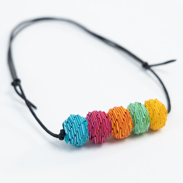 A multicolored paper beaded necklace with an adjustable leather strap by Irish maker Rike Lenzing