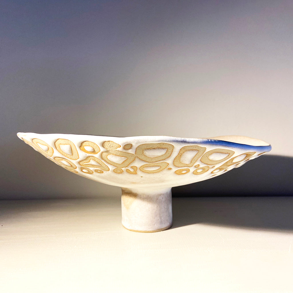 raised organic-shaped dish in a buff stoneware clay, simply finished with a loosely applied off-white matte glaze by contemporary ceramicist Sarah Bartlem
