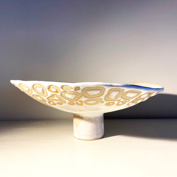 raised organic-shaped dish in a buff stoneware clay, simply finished with a loosely applied off-white matte glaze by contemporary ceramicist Sarah Bartlem