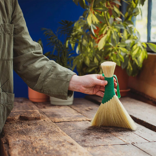 Person using a Tampico brush in a striking green - perfect for work surfaces in the home, workshop or garden. 