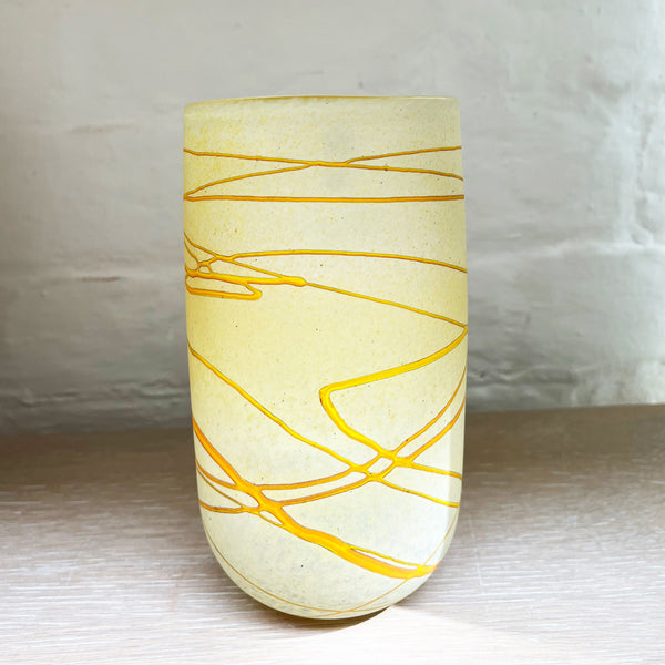 A medium vase from Will Shakspeare's 'Random Trails' range, inspired by walking in the Elan Valley in Wales.  This vase is predominently a vanilla colour with threads of gold colour. Will has been making his own inimitable glassware for nearly 30 years and is one of the country's most collected makers