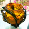 interior view of 'roots' orange bowl by contemporary glass artist Will Shakspeare. The piece is inspired by trees and is predominantly orange in colour with green 'roots'. one of the country's most collected contemporary makers.