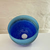 the interior of A small bowl by contemporary glass artist Will Shakspeare. The piece is inspired by the landscape of the Isles of Scilly and is predominantly blue in colour.
