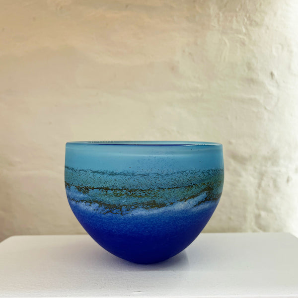A small bowl by contemporary glass artist Will Shakspeare. The piece is inspired by the landscape of the Isles of Scilly and is predominantly blue in colour.