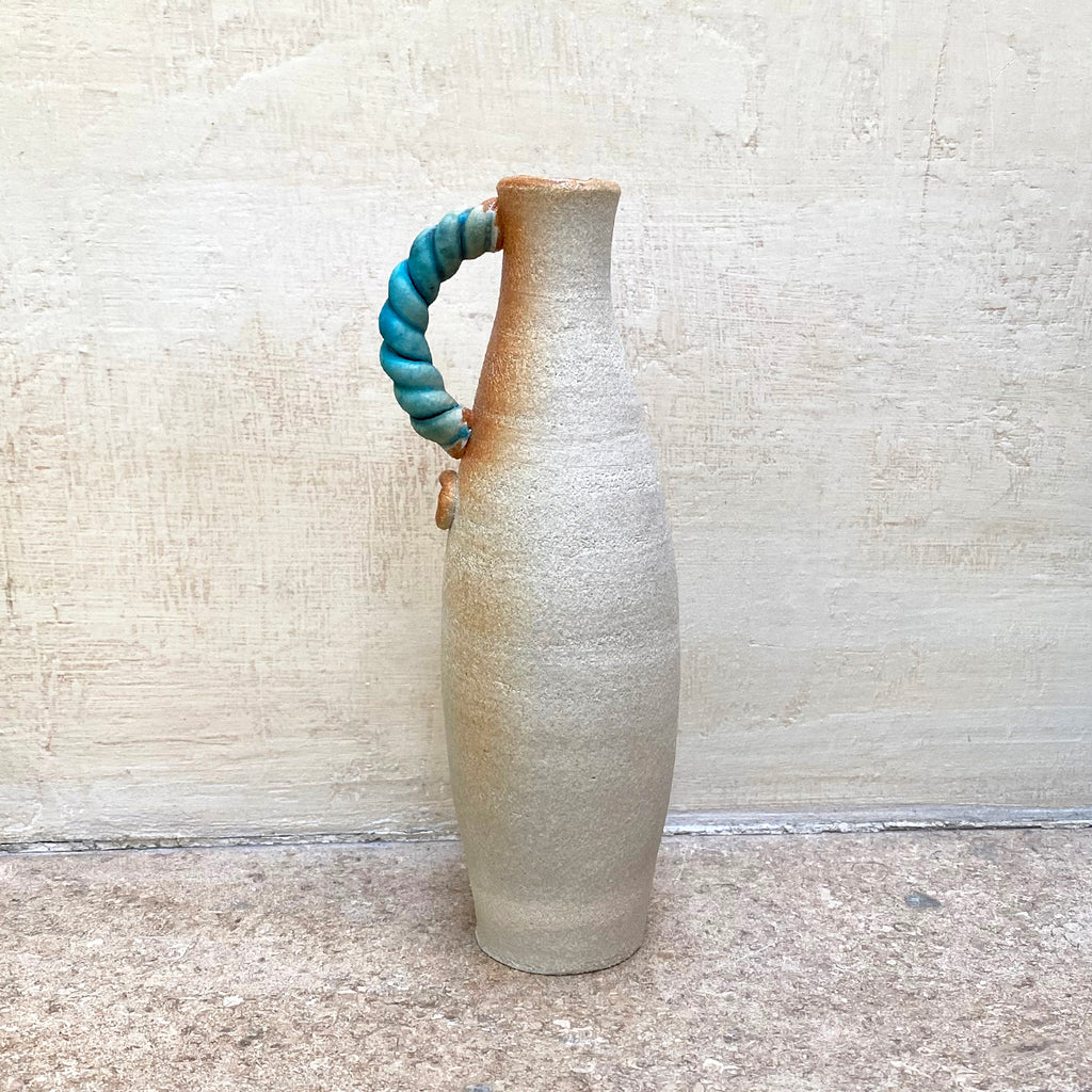 slim stoneware bottle vase with a blue twisted handle. The base of the twisted handle is adorned with John Kershaw’s signature stamp
