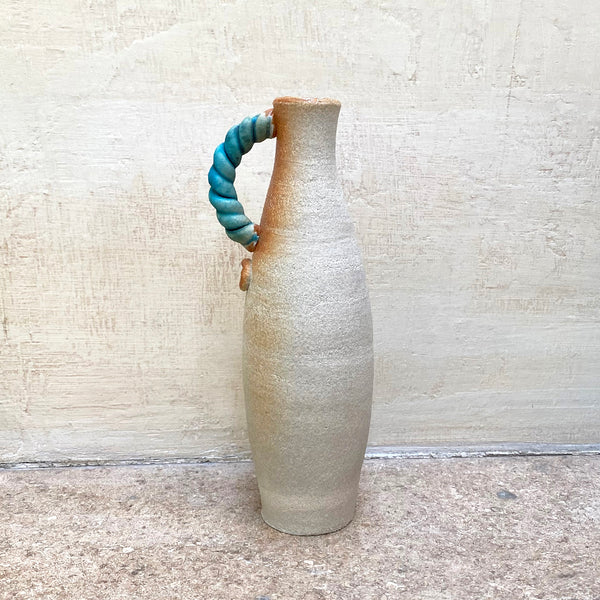 slim stoneware bottle vase with a blue twisted handle. The base of the twisted handle is adorned with John Kershaw’s signature stamp