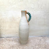 back view of slim stoneware bottle vase with a blue twisted handle. The base of the twisted handle is adorned with John Kershaw’s signature stamp