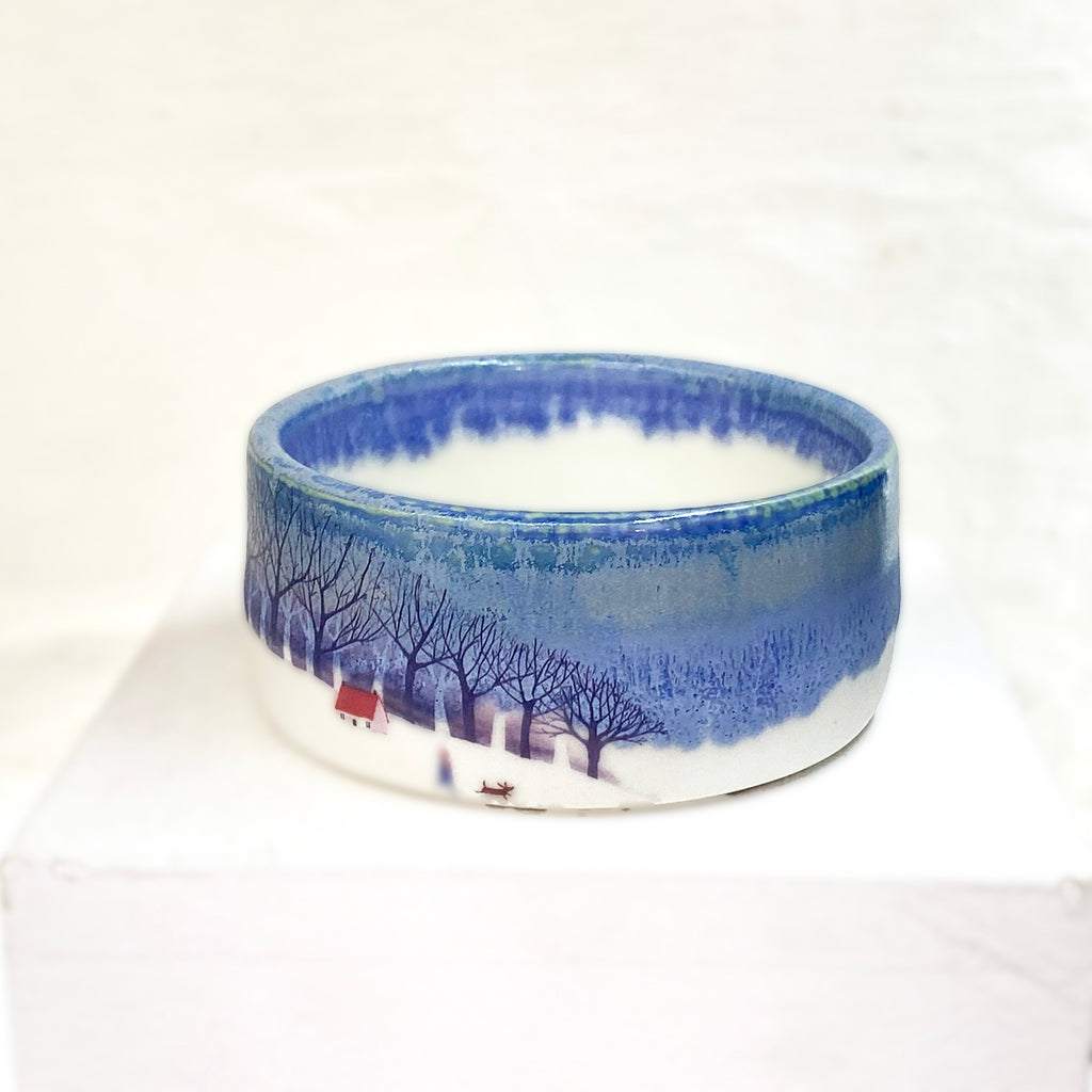 side view of beautiful small hand thrown blue bowl adorned with a homely winter scene by Julia Smith.